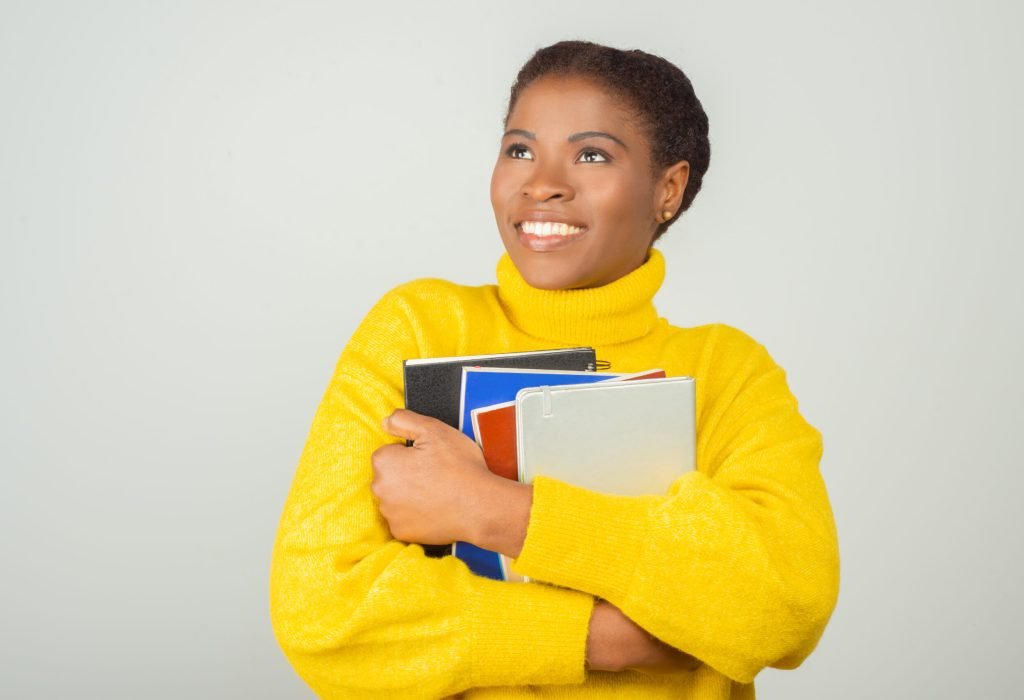 Happy joyful female student embracing books A happy student of our Private home tutoring services
